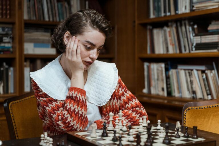 pensive woman looking at a chess set